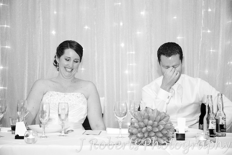 Bride and groom laughing during speeches at wedding reception - wedding photography sydney